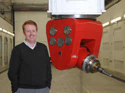 John Weller (PhD ’96) standing next to a 5-axis milling machine