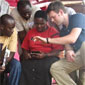 Doctoral student Carl Hartung (right) demonstrates the UW tool, Open Data Kit, in Uganda