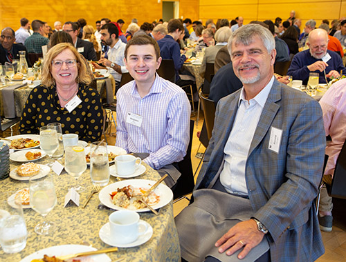 Sheila Litzinger and Ron Litzinger seated at a table with a student at the Scholar Donor Luncheon