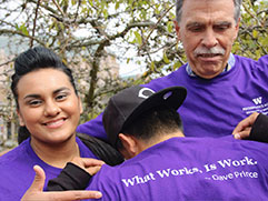 Dave Prince with students wearing shirts that say What works is work