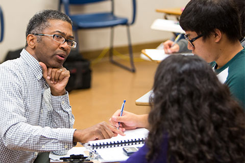 Sheldon Levias speaking with two students