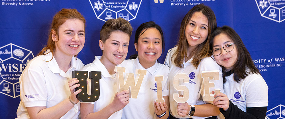 A group of students holding up letters that make up UWISE