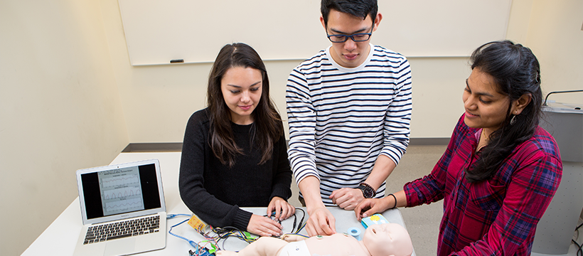 students demonstrating infant breathing monitor in lab