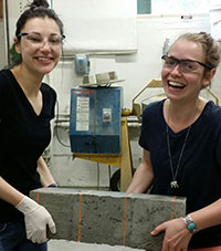 students carrying block of concrete