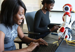 Students at PCs with robot