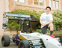 student with formula car in front of Guggenheim Hall