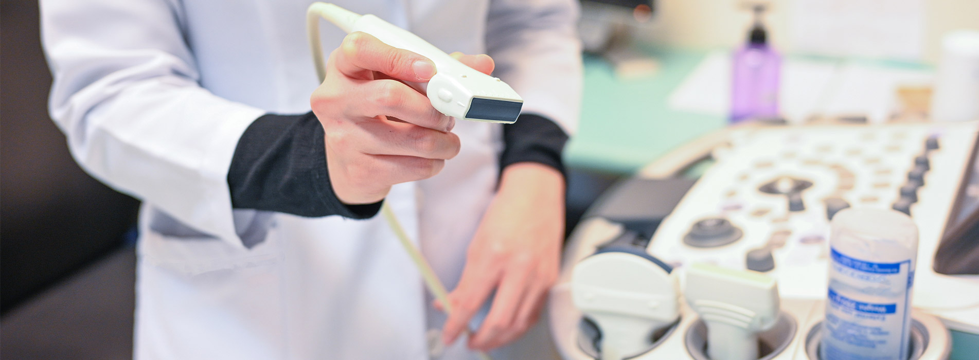 Person wearing lab coat performing ultrasound