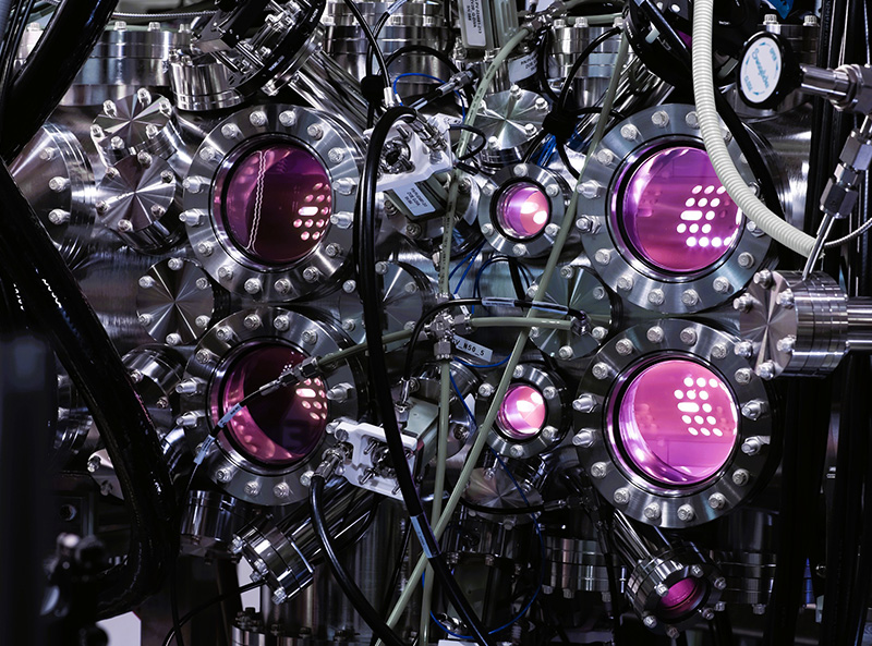 Complex machine with multiple magenta-hued lights pointing in different directions