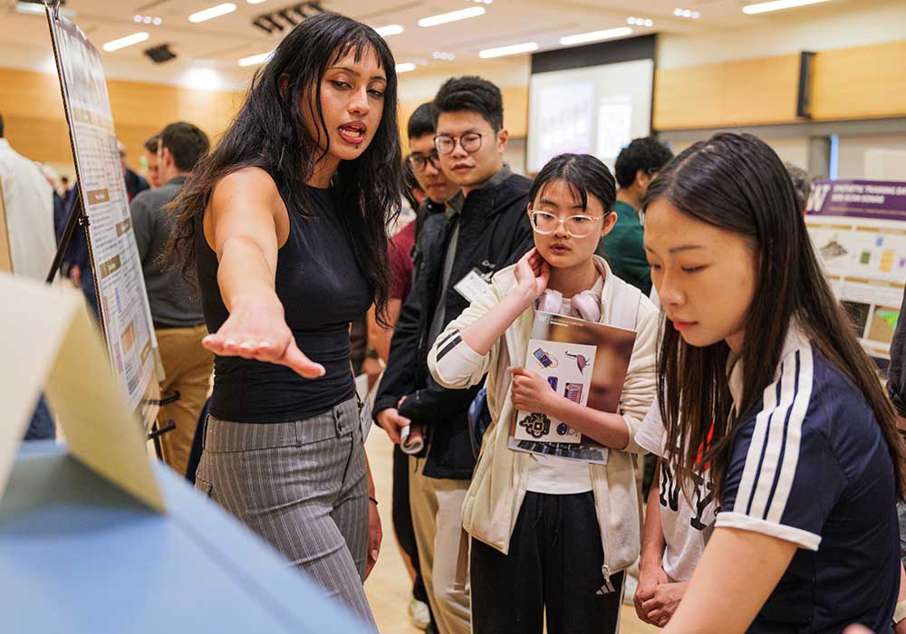 Students presenting the prototype and posters to other students during showcase
