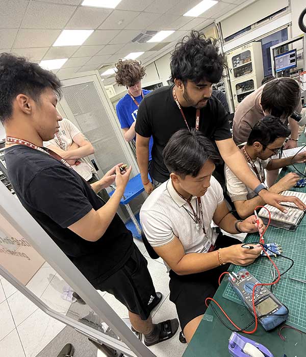 UW Engineering students work with electronic circuits and testing equipment in a laboratory, gaining hands-on experience with semiconductor and electronics technologies during a summer immersion program in Taiwan.