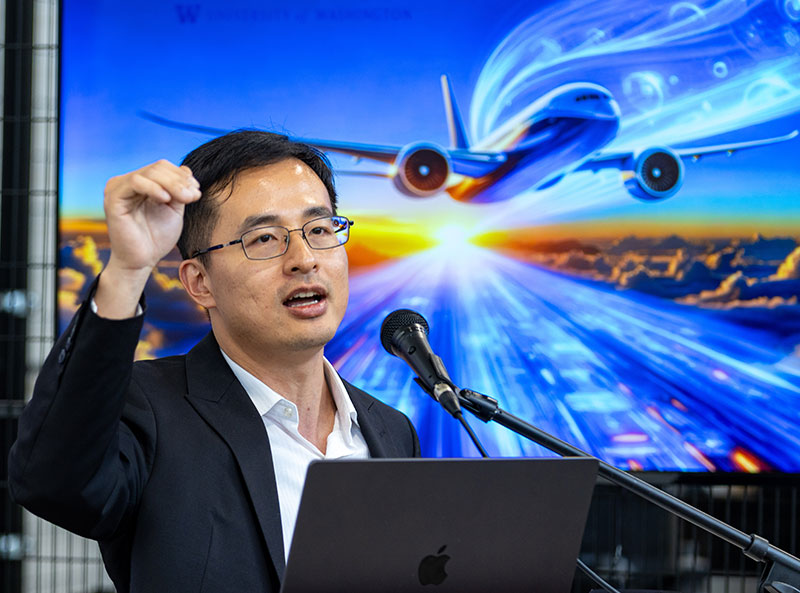 Xu Chen standing at a podium, speaking to event attendees