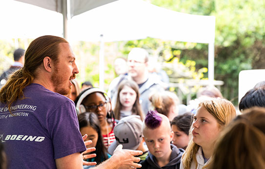 A UW student speaking to a group of youth