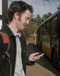 Brian Ferris with cell phone at bus stop