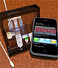 the pieces necessary for a field-based diagnostic test, including a swab, a smartphone and the testing device