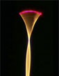 Microfabricated optical fiber scanner emitting red laser light