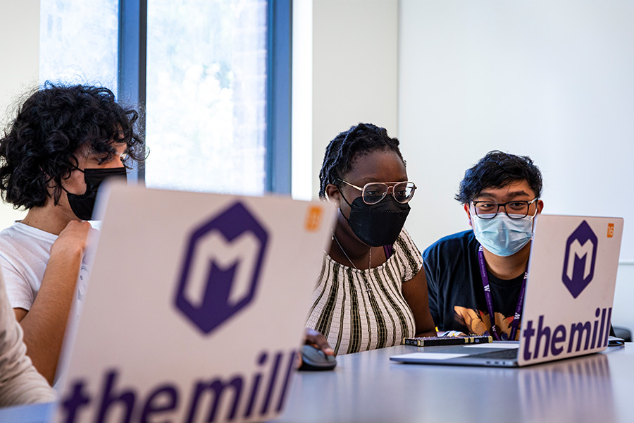 A group of students sitting in front of laptops