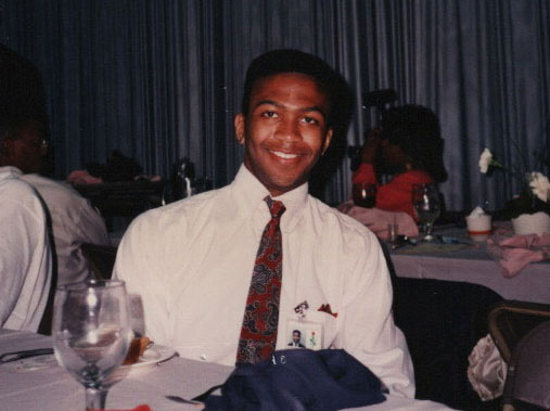A younger Sheldon sitting at a banquet