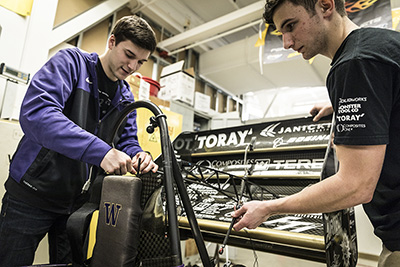 Two Formula members working on the car