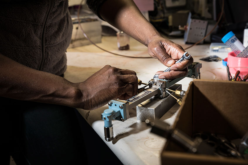 closeup of Igbinosun's hands using tools