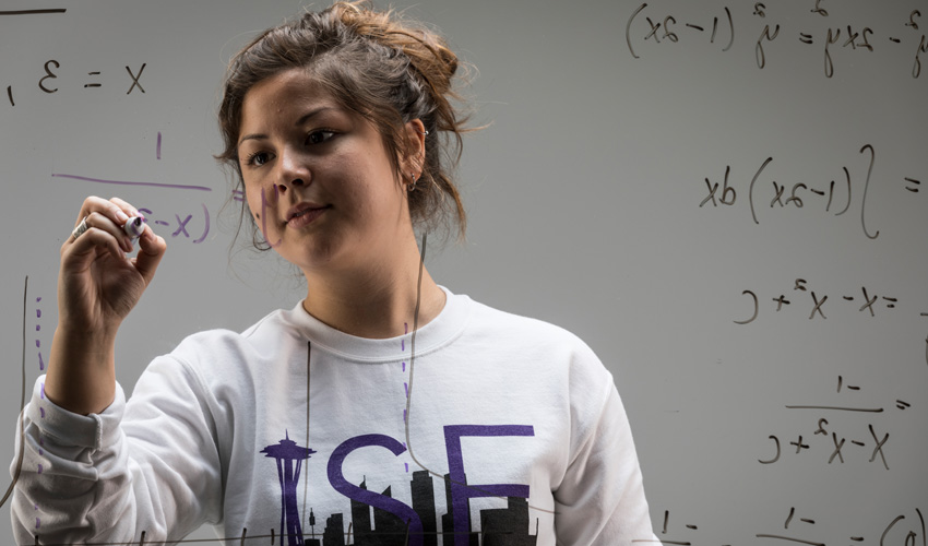 Courtney Seto writing equations on whiteboard