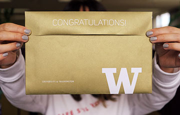 future student holding UW admission notification envelope