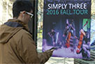 smartphone user tuning in to music from a poster
