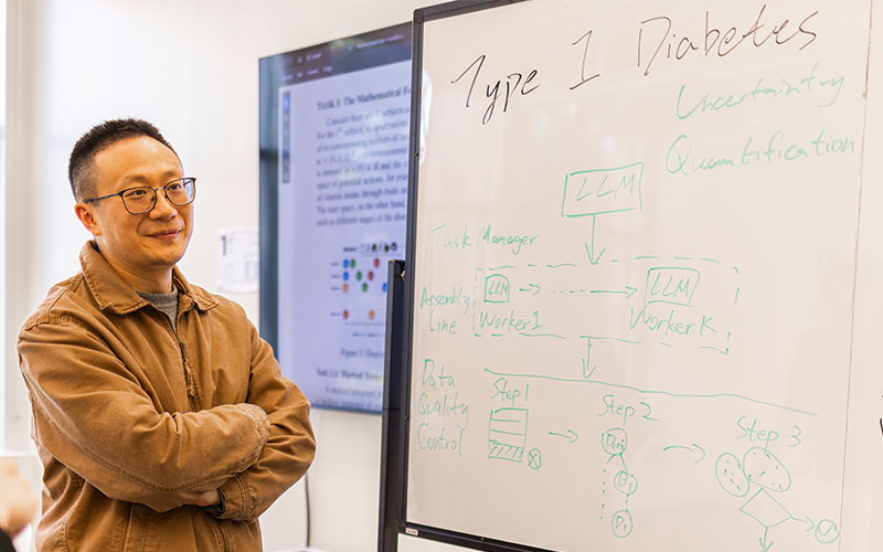 Person standing next to whiteboard, Type 1 Diabetes is written on it