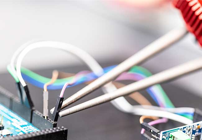 Close-up of electronic components with multicolored wires connected to a circuit board.