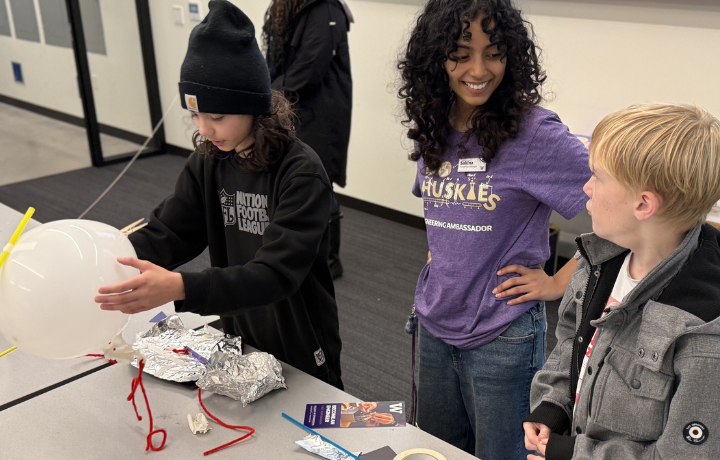 Engineering student working with young students in classroom
