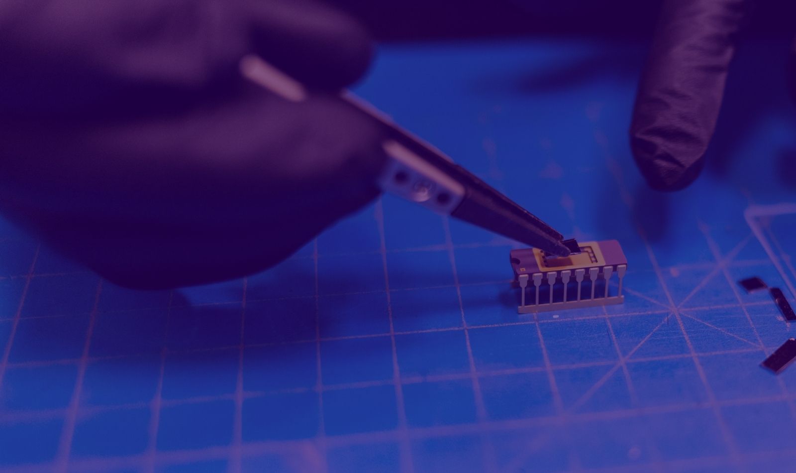 Close up of a person's hand holding precision tools working on chip