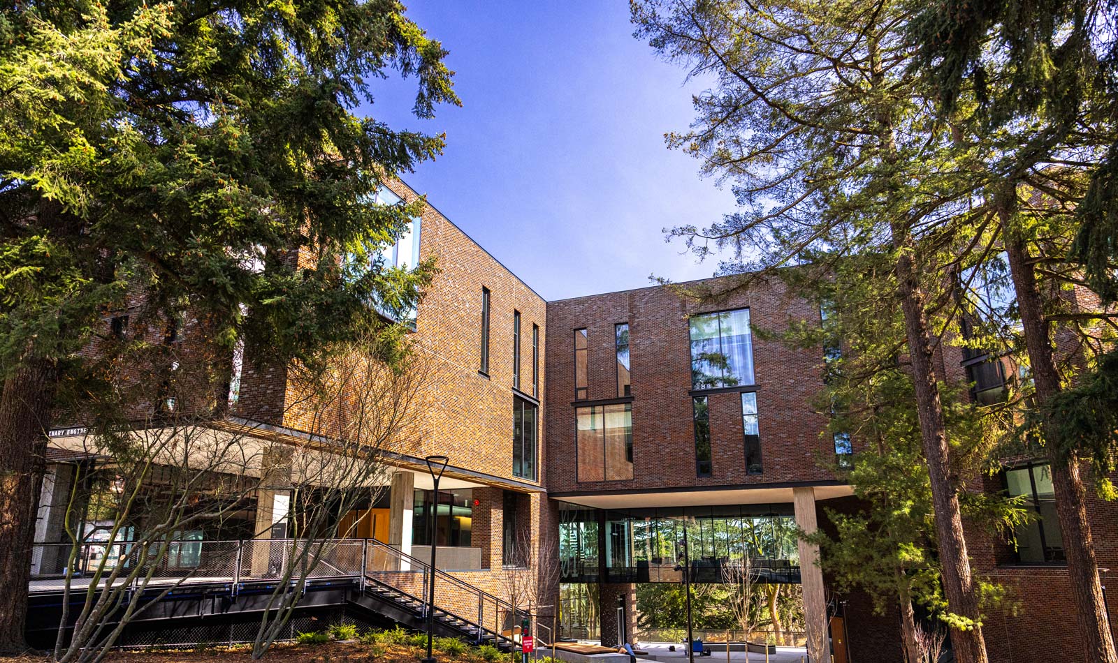 Photo of the exterior of the IEB building's brick architecture with surrounding trees under a blue sky.