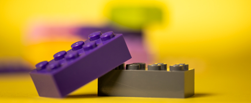 Close-up of purple and gray LEGO bricks against a gold background.