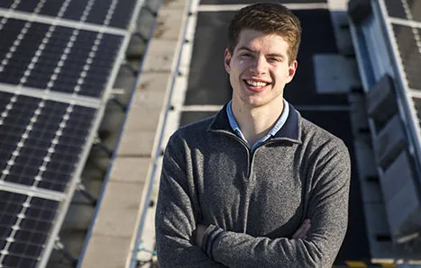 CEE student Alex Ratcliff standing in front of solar panels