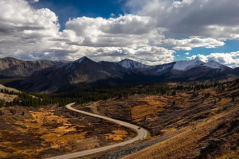 A winding road leading to snow-capped mountains in the distance