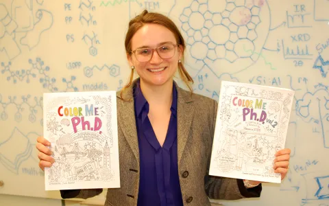 Woman holding two books and smiling to the camera