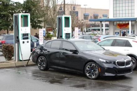 Electric car plugged in and charging at a charging station