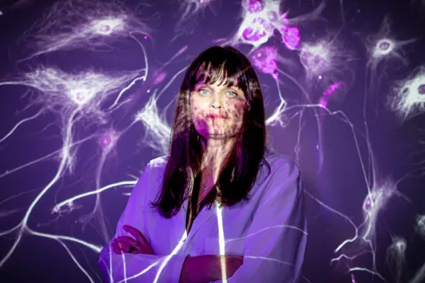 Kristin Bennett standing in front of a white and purple wall