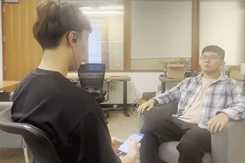Two men sitting across from each other on chairs