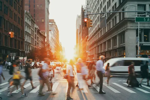 People walk across a crosswalk.