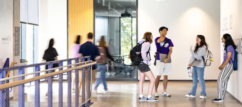 Students talking in the middle of IEB hallway