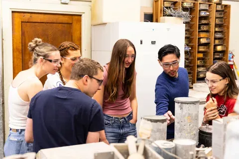 Group of people in a lab examining concrete samples