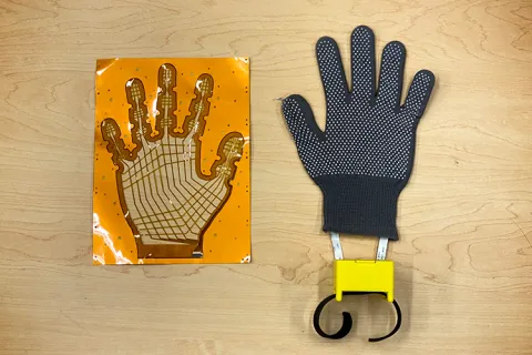 Two pieces of an electronic glove lie on a table.