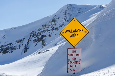 Snowy mountains with two signs in foreground.