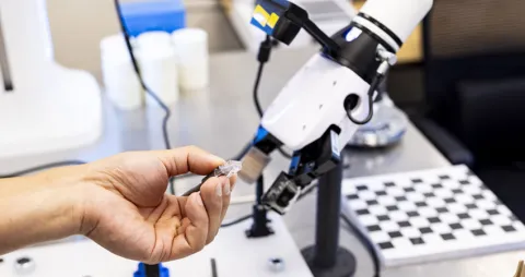 Robotic arm and other advanced machinery being handled by a human hand
