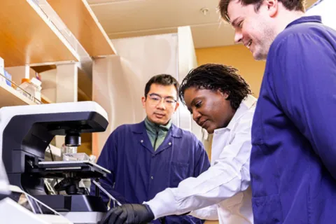 Three people standing in a lab