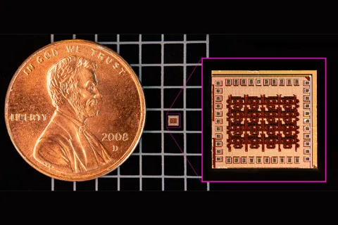 A microchip sits on a grid next to a much larger penny. An inset box shows a larger, more detailed image of the microchip