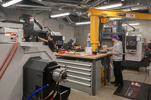 Two men in a machine shop in the IEB
