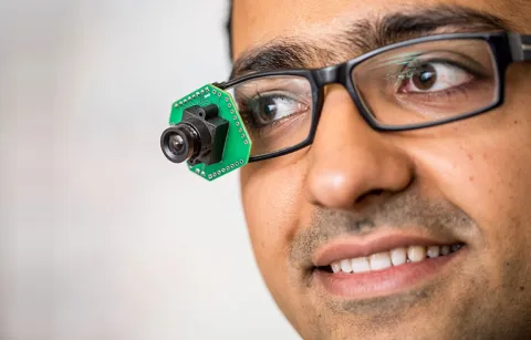 man wearing low-power, video-streaming prototype camera; photo by Dennis Wise/UW