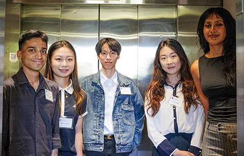 Five people standing in an elevator