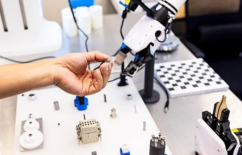Robotic arm and other advanced machinery being handled by a human hand